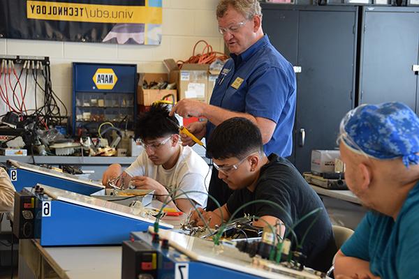 Tech students hooking up wires to boards