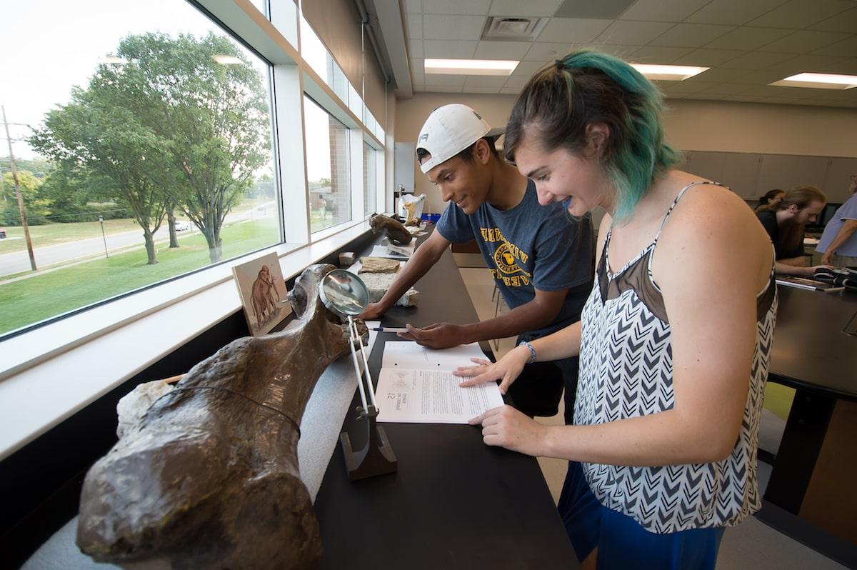 地球科学 students examining a large bone